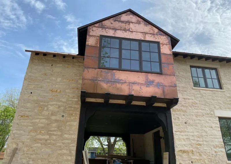 Copper metal panel facade on a stone building for Metal Roof Coating in Harrisonville
